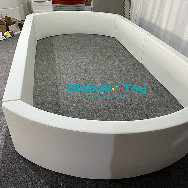 Vista dall'alto di una vasca ovale con palline soft play per uso interno.