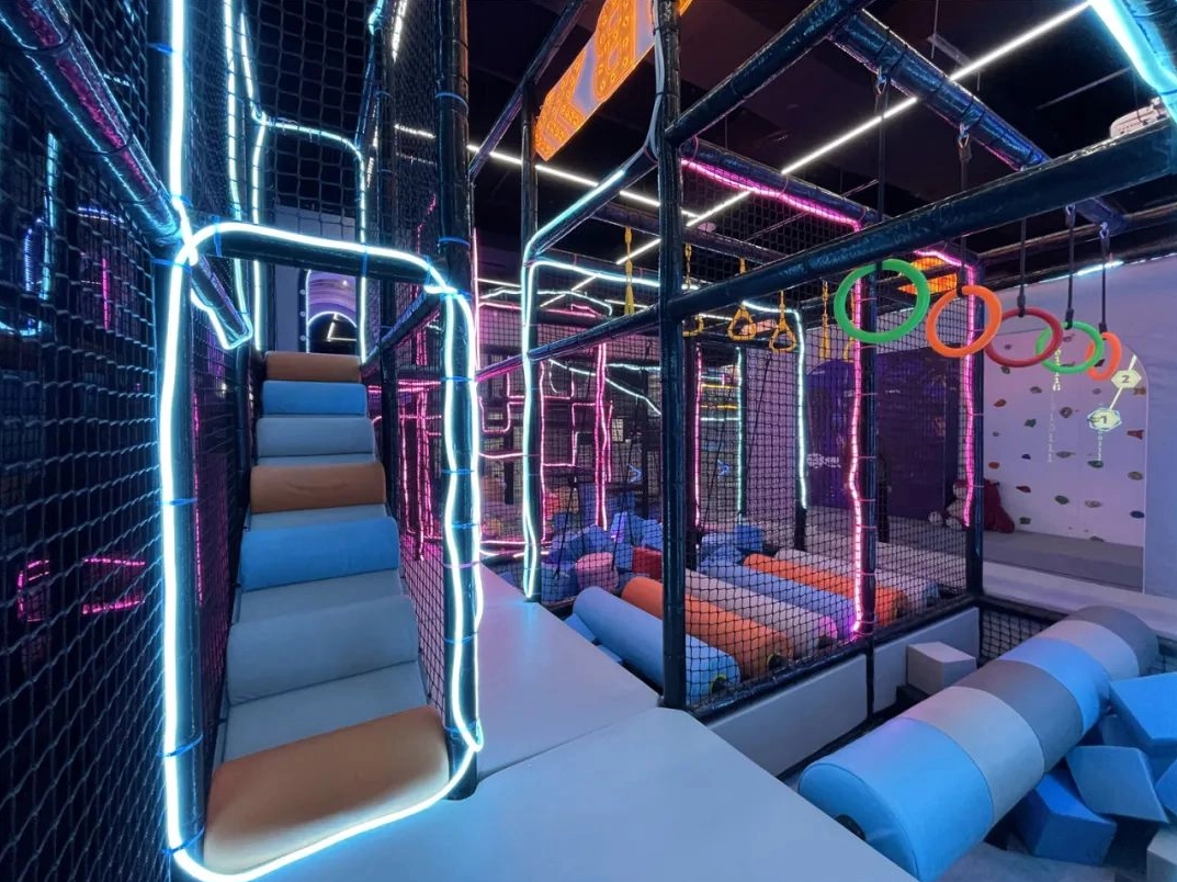 Attrezzature per parchi giochi al coperto con ostacoli da arrampicata e strutture di gioco morbide al neon